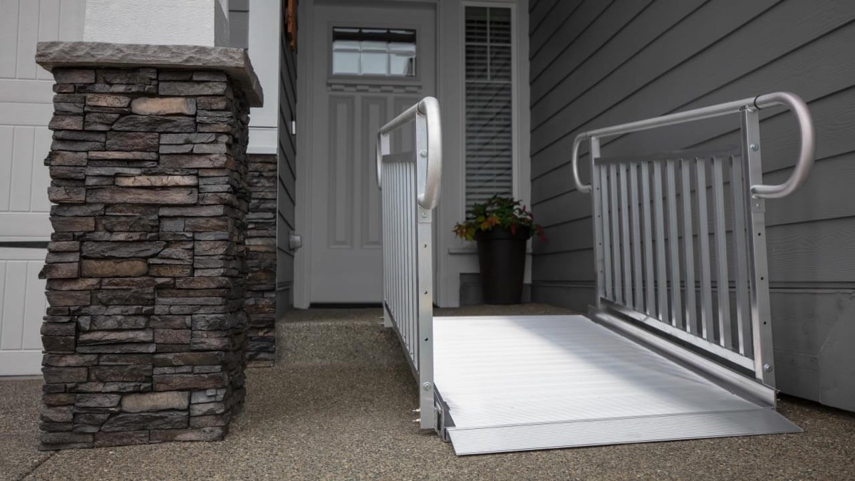 Aluminum entry ramp with sturdy handrails on both sides at a home entrance